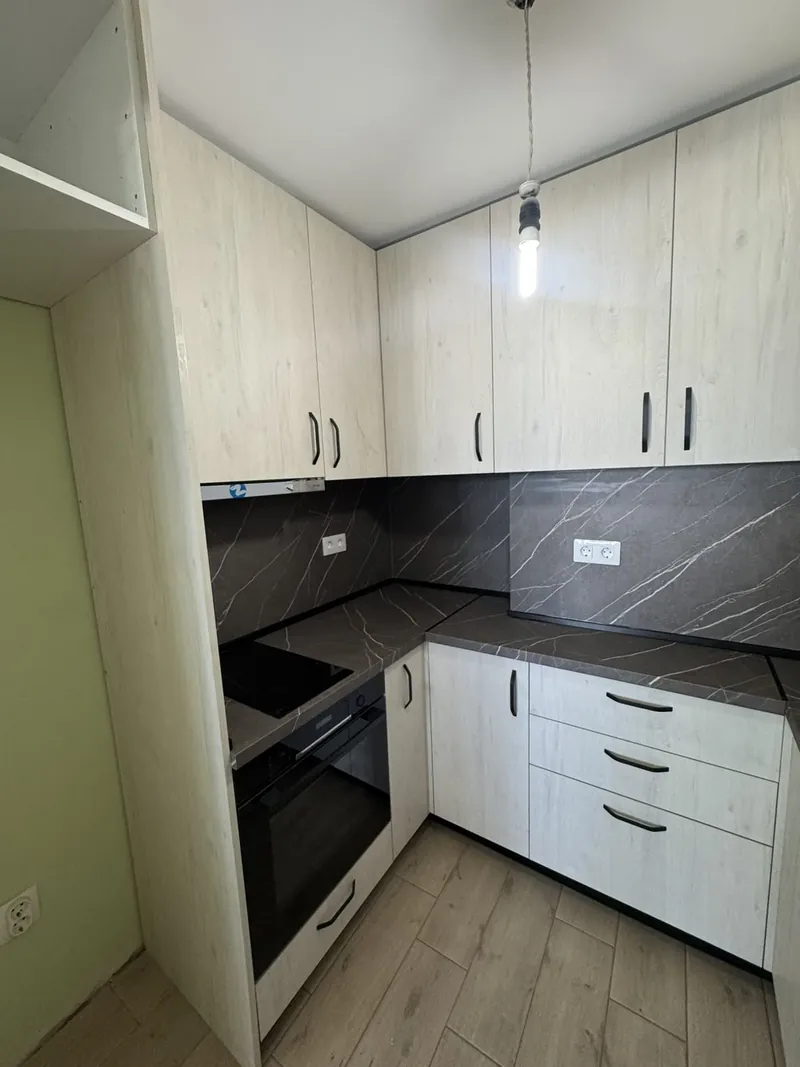 Apartment kitchen in light wood and white