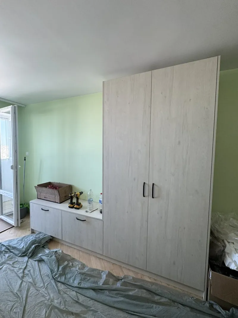 Tall built-in wardrobe beside a low cabinet