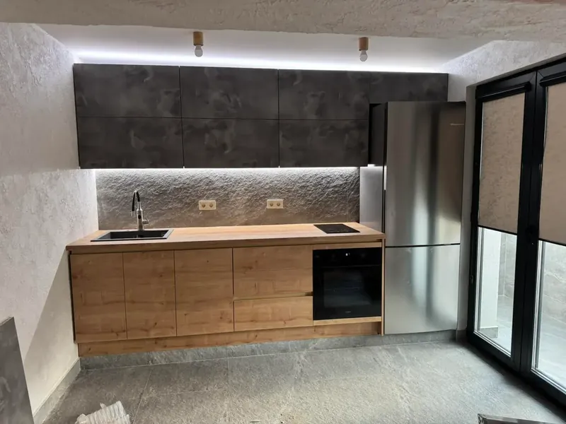 Concrete-effect wall units over oak base units with under-cabinet lighting
