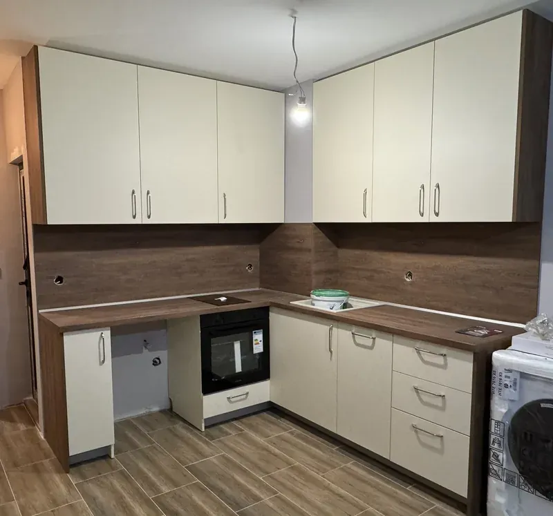 Cream kitchen with a dark wood worktop and splashback