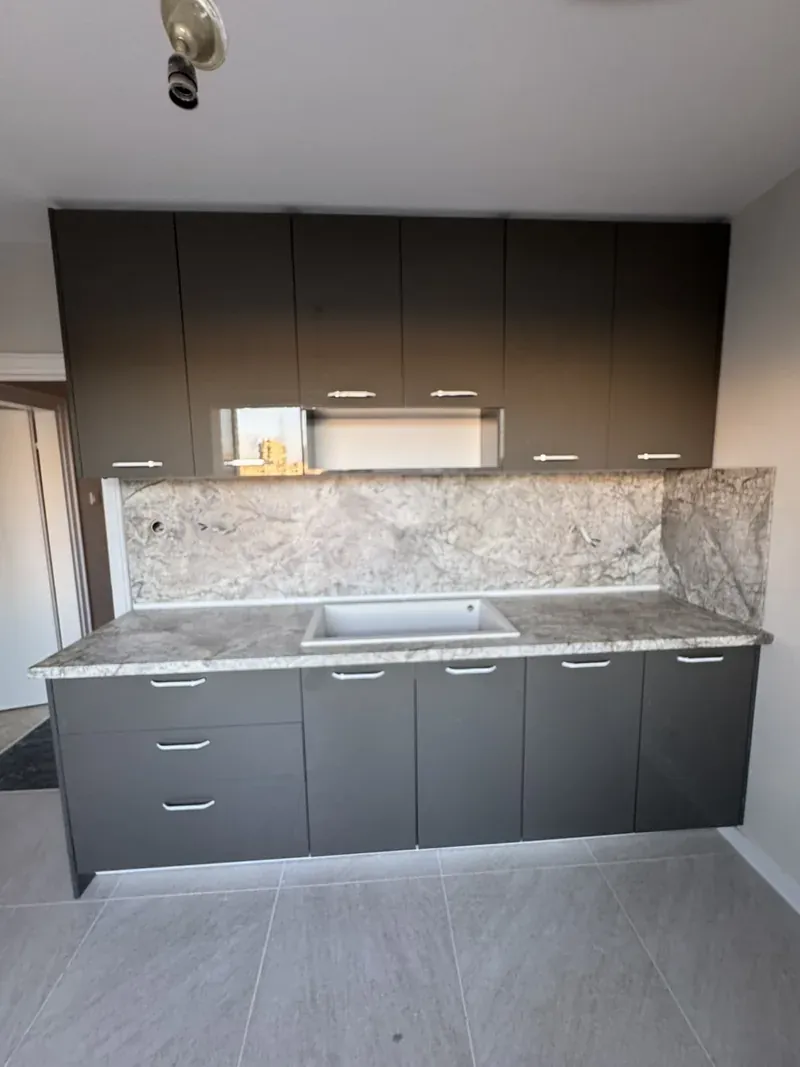 Grey kitchen with granite-effect splashback and wood wall cabinets