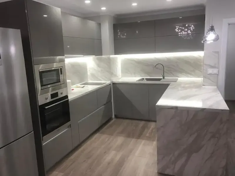 U-shaped grey gloss kitchen with a peninsula and marble-effect worktop